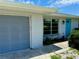 Front view of a single-story house with a gray garage door and blue front door at 3553 Syracuse St, Port Charlotte, FL 33952