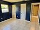 Spacious bedroom with dark blue walls and tile floors. Features multiple doors and a window at 3553 Syracuse St, Port Charlotte, FL 33952