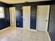 Spacious bedroom with dark blue walls and tile floors. Features multiple doors and a window at 3553 Syracuse St, Port Charlotte, FL 33952