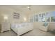 Spacious main bedroom with white furniture and access to balcony at 1260 Dolphin Bay Way # 203, Sarasota, FL 34242