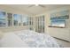 Comfortable main bedroom with white wood furniture and a large TV at 1260 Dolphin Bay Way # 203, Sarasota, FL 34242