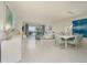 Modern dining room with white table, blue patterned chairs, and large artwork at 1260 Dolphin Bay Way # 203, Sarasota, FL 34242