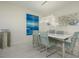 Modern dining area with a white table and stylish blue patterned chairs at 1260 Dolphin Bay Way # 203, Sarasota, FL 34242