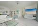 Open concept living room with a large TV, comfortable seating, and a view to the lanai at 1260 Dolphin Bay Way # 203, Sarasota, FL 34242