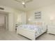 Bright main bedroom with white furniture and mirrored closet doors at 1260 Dolphin Bay Way # 203, Sarasota, FL 34242