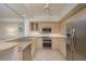 Modern kitchen with light wood cabinets, granite counters, and stainless steel appliances at 1260 Dolphin Bay Way # 203, Sarasota, FL 34242