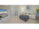 Bright living room with white couch, gray ottoman, and view of ocean at 1260 Dolphin Bay Way # 203, Sarasota, FL 34242