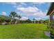 Large lush backyard with a white fence, well manicured lawn, and tropical landscaping at 2352 Marton Oak Blvd, North Port, FL 34289