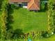 Aerial view of a large, green backyard surrounded by lush tropical landscaping at 2352 Marton Oak Blvd, North Port, FL 34289
