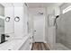 Modern bathroom featuring a glass-enclosed shower and dual sinks with white cabinetry at 2352 Marton Oak Blvd, North Port, FL 34289