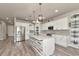 Bright kitchen features a large island, white cabinets, stainless steel appliances, and decorative backsplash at 2352 Marton Oak Blvd, North Port, FL 34289