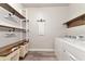 Efficient laundry room with washer, dryer, storage shelves, and convenient laundry bins at 2352 Marton Oak Blvd, North Port, FL 34289