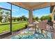Screened-in patio featuring an outdoor dining set and lush green backyard at 2352 Marton Oak Blvd, North Port, FL 34289