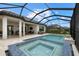 Backyard view of a screened-in pool and jacuzzi, plus covered seating area, creating a private outdoor oasis at 3107 Vittorio Ct, Bradenton, FL 34211