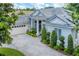 Charming home with a gray tile roof, white exterior, and well-manicured landscaping at 6935 Cumberland Ter, University Park, FL 34201