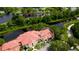 Aerial view of townhouse community near a pond surrounded by lush landscaping and a golf course at 4751 Travini Circle # 4-116, Sarasota, FL 34235
