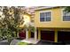 Charming townhouse with red garage doors, a well-manicured lawn, and mature trees at 4751 Travini Circle # 4-116, Sarasota, FL 34235