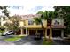 Beautiful townhouse with red garage doors and a paved driveway, nestled among lush greenery and palm trees at 4751 Travini Circle # 4-116, Sarasota, FL 34235