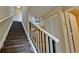 Carpeted staircase with white handrail and black banister leading to the kitchen at 4751 Travini Circle # 4-116, Sarasota, FL 34235