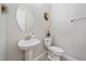 Clean powder room with pedestal sink, toilet and oval mirror at 16922 Scuba Crest St, Wimauma, FL 33598