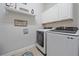 Convenient laundry room with modern washer, dryer, and overhead shelving at 16922 Scuba Crest St, Wimauma, FL 33598