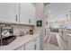 Well-equipped kitchen with white cabinetry, quartz countertops and coffee bar at 16922 Scuba Crest St, Wimauma, FL 33598