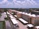 Aerial shot of the condo complex and carports surrounded by tropical landscape at 1300 N Portofino Dr # 208, Sarasota, FL 34242