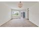 Cozy bedroom with neutral carpet, large window, and balcony access at 1300 N Portofino Dr # 208, Sarasota, FL 34242