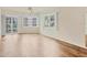 Bright living room with sliding doors to a balcony, ceiling fan, and hardwood floors at 1300 N Portofino Dr # 208, Sarasota, FL 34242