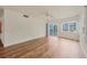 Open-concept living room with a ceiling fan, sliding glass doors, and beautiful hardwood floors at 1300 N Portofino Dr # 208, Sarasota, FL 34242