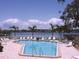 Inviting outdoor pool with lounge chairs overlooking tranquil waterfront at 1300 N Portofino Dr # 208, Sarasota, FL 34242