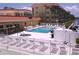 Inviting community pool and hot tub area with lounge chairs, shuffleboard, and a canal view at 1300 N Portofino Dr # 208, Sarasota, FL 34242