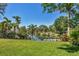 Lush backyard with a verdant lawn, mature trees, and direct access to a tranquil canal at 1707 Caribbean Dr, Sarasota, FL 34231