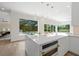 The kitchen has pendant lighting over the island with pool view from kitchen window at 1707 Caribbean Dr, Sarasota, FL 34231