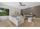 Elegant living room with a modern white sectional, stylish wallpaper, and warm wood floors at 1707 Caribbean Dr, Sarasota, FL 34231