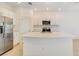 Open concept kitchen with white cabinets and expansive island at 3149 Novara Ln, Lakewood Ranch, FL 34211