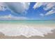 White sand beach with ocean waves at 1300 N Portofino Dr # 208, Sarasota, FL 34242