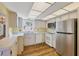 Kitchen with light cabinets, stainless steel appliances, and wood floors at 1300 N Portofino Dr # 208, Sarasota, FL 34242