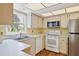 Bright kitchen featuring white appliances and wood flooring at 1300 N Portofino Dr # 208, Sarasota, FL 34242