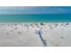 Drone shot of beach with people sunbathing and swimming at 1300 N Portofino Dr # 208, Sarasota, FL 34242