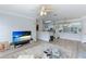 Open living room features hardwood floors, a large TV, and an open concept kitchen at 4802 51St W St # 1305, Bradenton, FL 34210