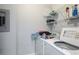 Convenient laundry room with washer, dryer, and shelving for storage at 4802 51St W St # 1305, Bradenton, FL 34210