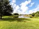 Scenic backyard view with a peaceful pond reflecting the blue sky and fluffy white clouds at 11406 Belvedere Ter, Lakewood Ranch, FL 34211
