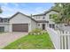 Two-story home with a two-car garage, brick paver driveway, and well-maintained front yard with a white picket fence at 1807 Robinhood St, Sarasota, FL 34231