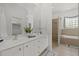 Bathroom featuring double vanity, walk in shower, and soaking tub at 974 Rotonda Cir, Rotonda West, FL 33947