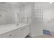 Bright bathroom with a modern vanity, large mirror, and glass block window feature at 974 Rotonda Cir, Rotonda West, FL 33947