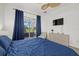 Comfortable bedroom featuring a large window, dresser, and a blue comforter at 974 Rotonda Cir, Rotonda West, FL 33947