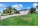 Attractive exterior showcasing manicured lawn, palm trees, and a three-car garage at 974 Rotonda Cir, Rotonda West, FL 33947