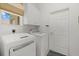 Bright laundry room featuring modern washer and dryer units, cabinetry, and a window for natural light at 974 Rotonda Cir, Rotonda West, FL 33947