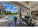 A screened-in patio featuring ample seating and views of the pool and lush surroundings at 974 Rotonda Cir, Rotonda West, FL 33947